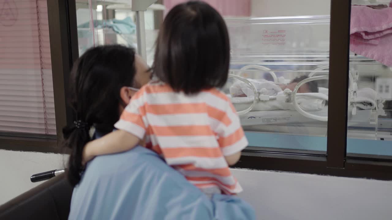 妈妈和女儿看起来像在保育箱里的婴儿视频素材
