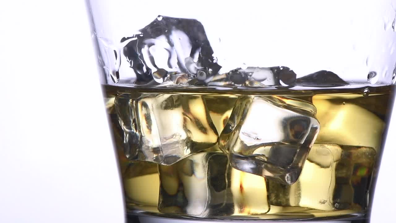 将苏打水倒在冰块和威士忌上的慢镜头，饮料概念视频素材