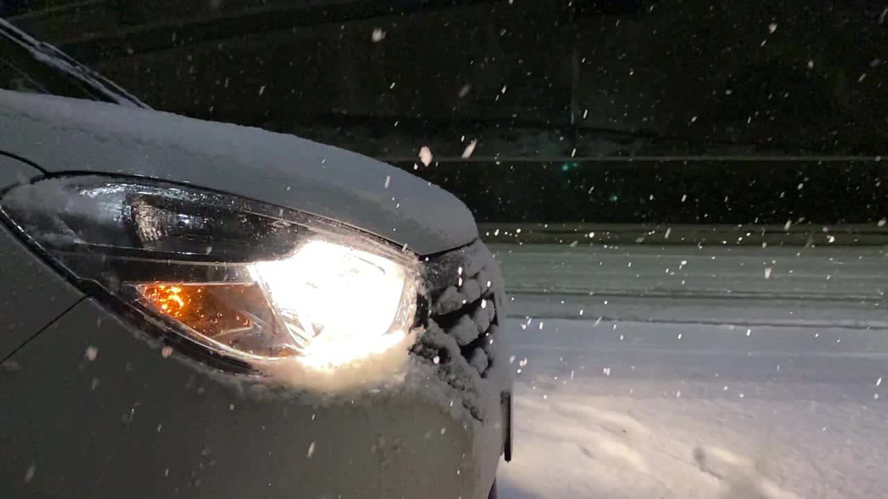 汽车的前灯照亮了雪景。缓慢的运动。视频下载