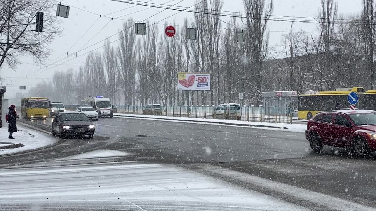 城市里的汽车交通和降雪。缓慢的运动。视频下载