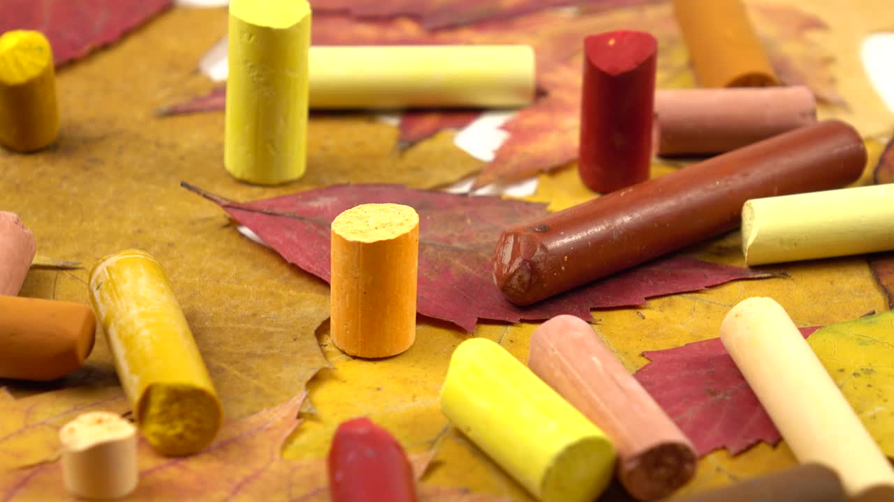 黄色、红色和橙色的蜡笔和秋天的树叶视频素材