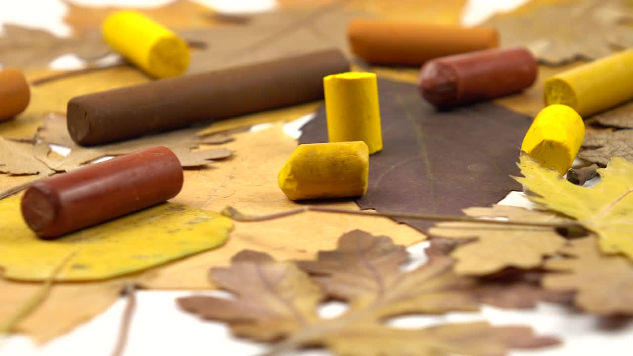 黄色和棕色的蜡笔和秋天的树叶视频素材