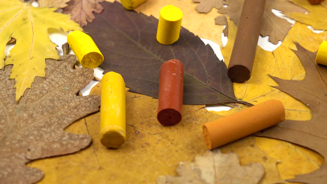 黄色和棕色的蜡笔和秋天的树叶视频素材