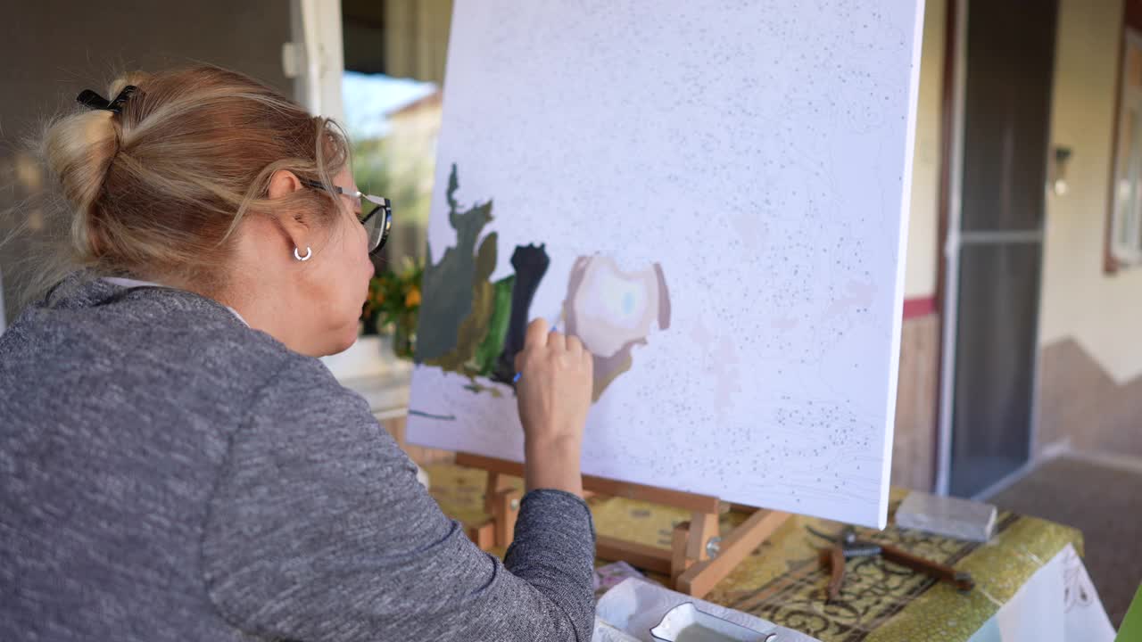 女艺术家用画笔画一幅数字画，这是初学者绘画的简单方法视频下载