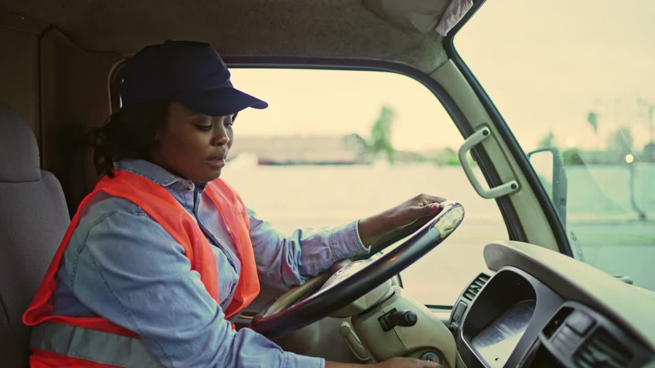 年轻的女卡车司机正在检查智能手机视频素材