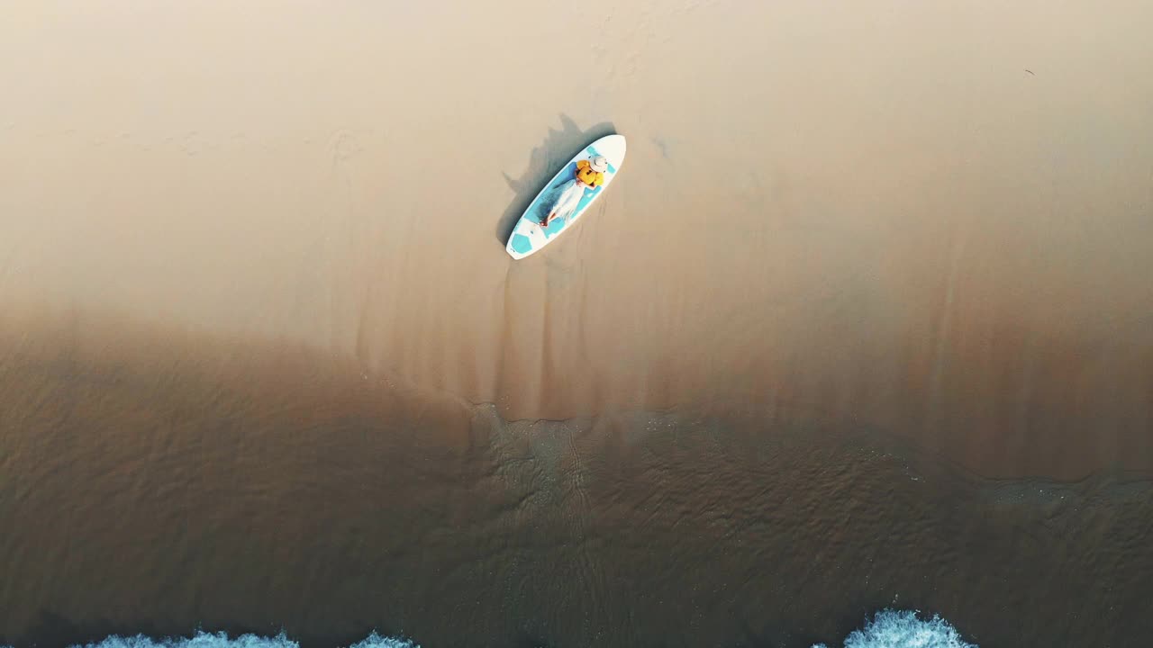 鸟瞰图放松的女人在海滩上划桨broad视频下载
