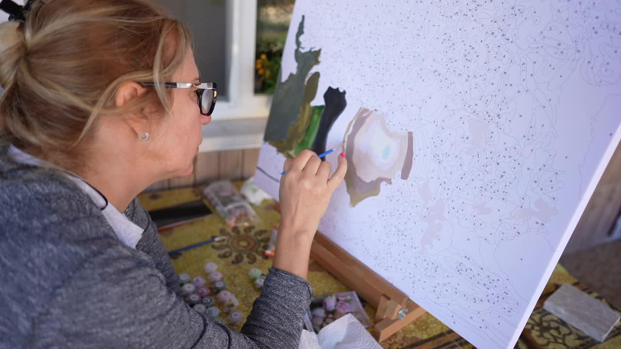 女艺术家用画笔画一幅数字画，这是初学者绘画的简单方法视频下载