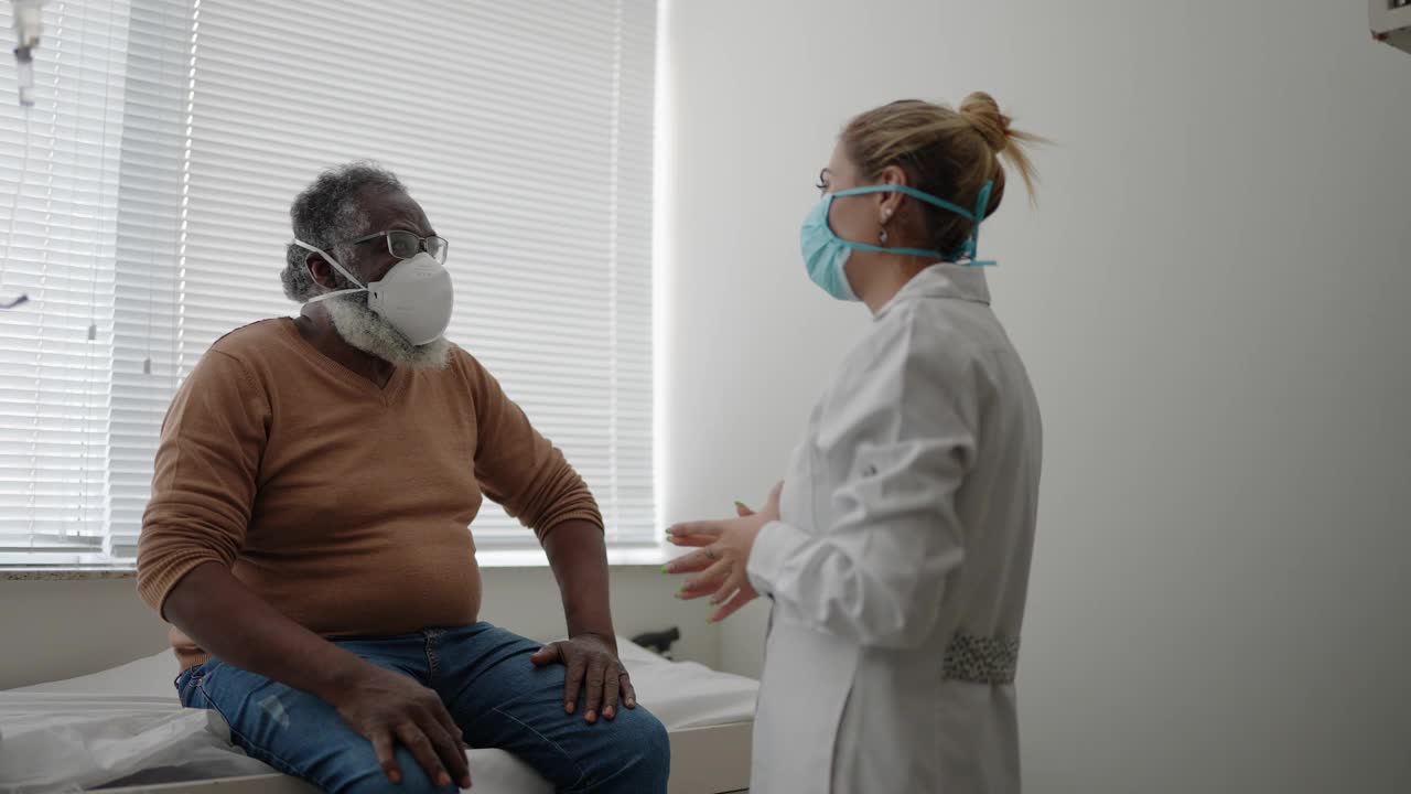 病人戴着防护口罩与医生交谈视频下载