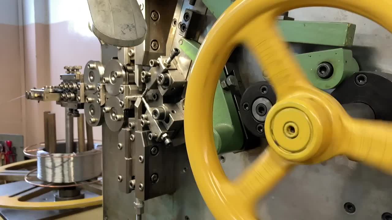 机器上的弹簧绕线。制造弹簧的生产。慢动作视频。视频素材