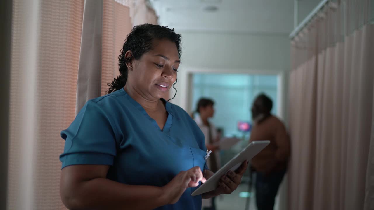一个快乐的护士在医院使用电子平板电脑视频素材