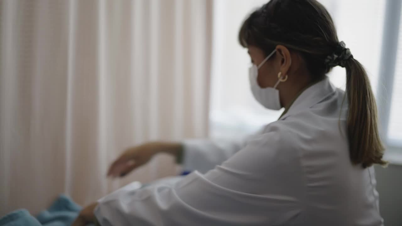 女医生在医院为躺在床上的病人包扎视频素材