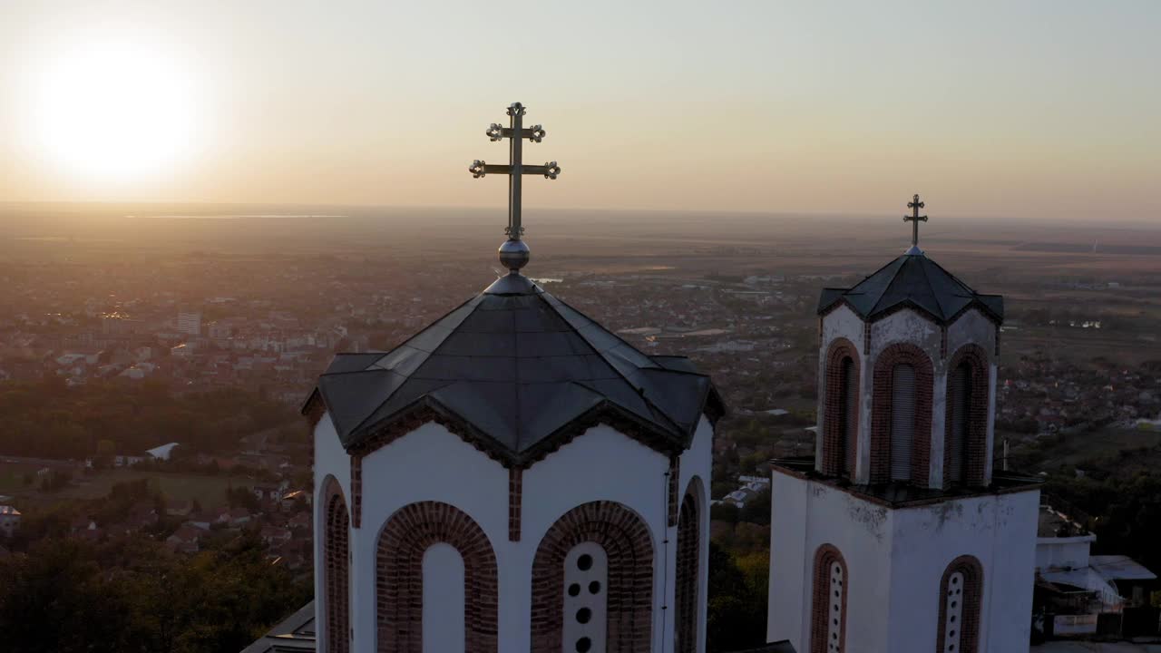 无人机拍摄的日落中有十字架的教堂塔视频素材