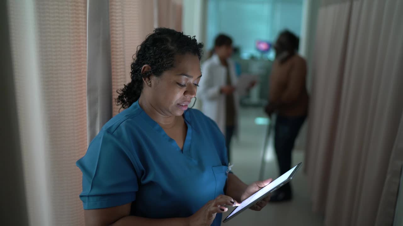 一个快乐的护士在医院使用电子平板电脑视频素材