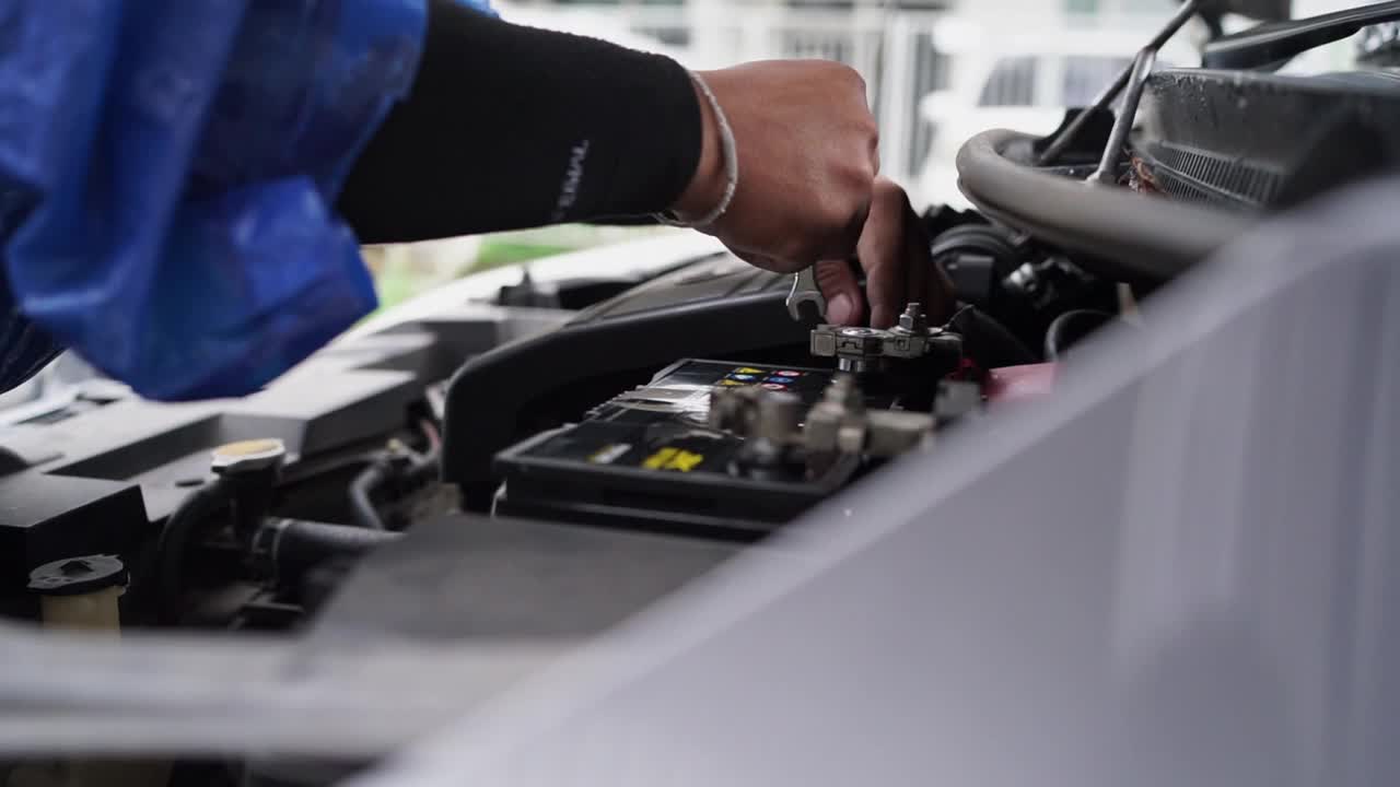 慢动作手的汽车修理工更换新电池并修理它视频下载