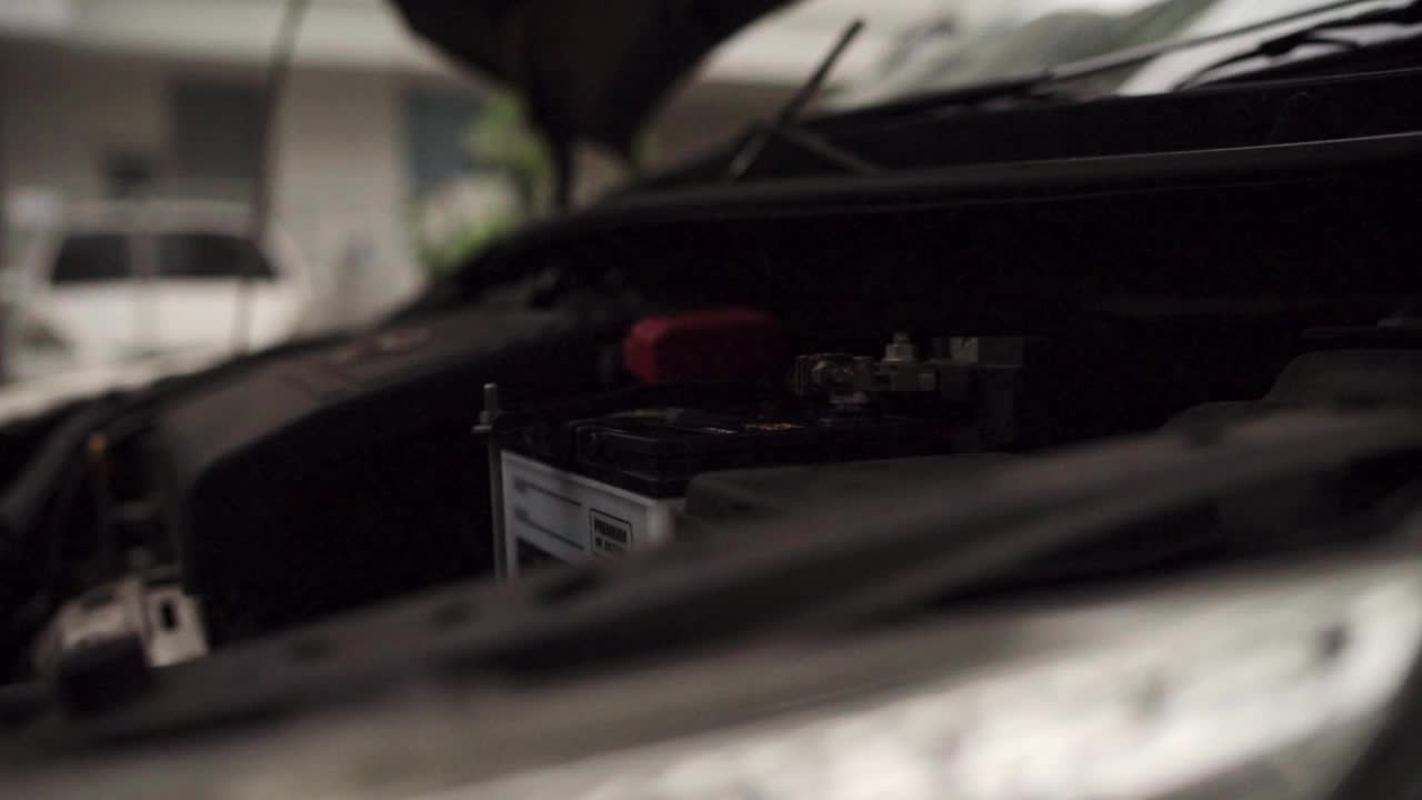 慢动作手的汽车修理工更换新电池并修理它视频下载