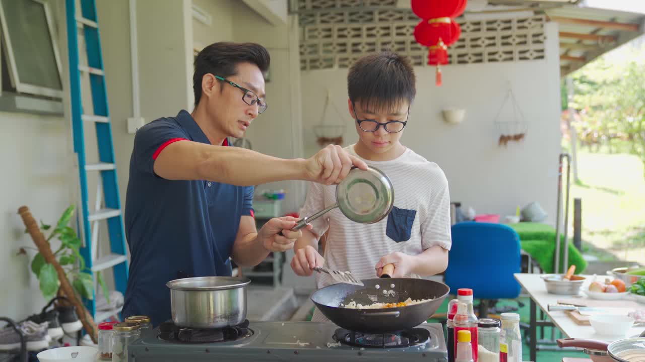 亚洲华人父亲和儿子一起在潮湿的厨房后院周末准备晚餐视频下载