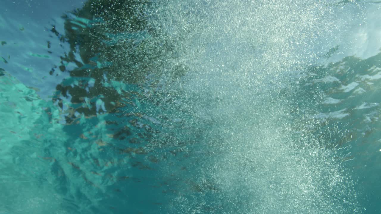 对游泳池中气泡的水下pov进行中角平移。水池墙上可见蓝色瓷砖。视频素材