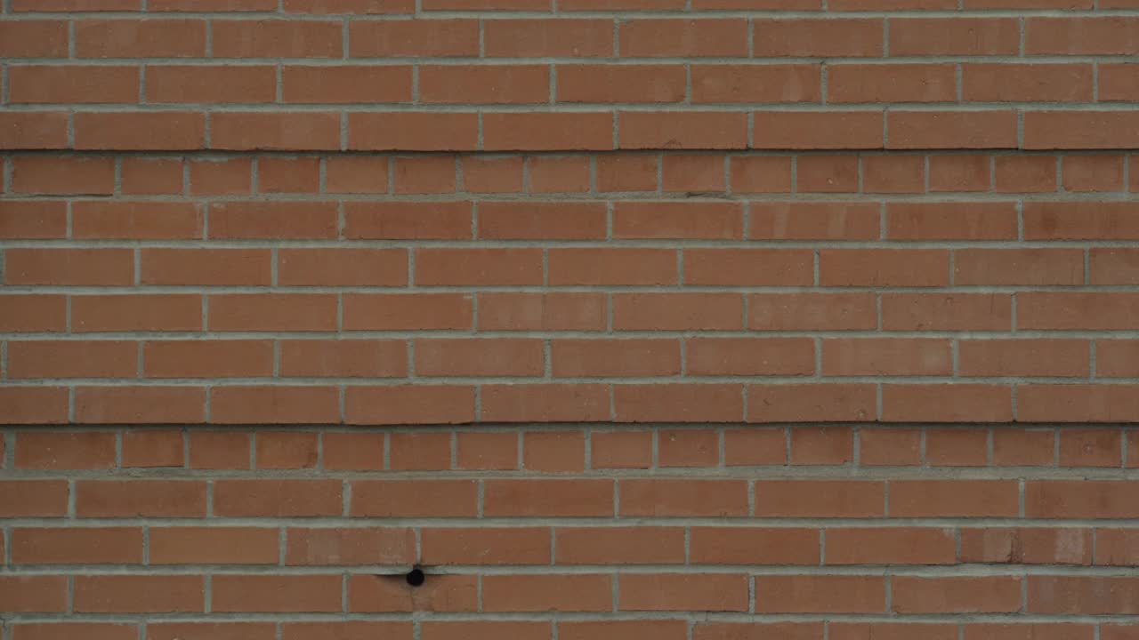 砖墙或砖房的封闭角。墙上的小洞。可能是弹孔或通风口。视频素材