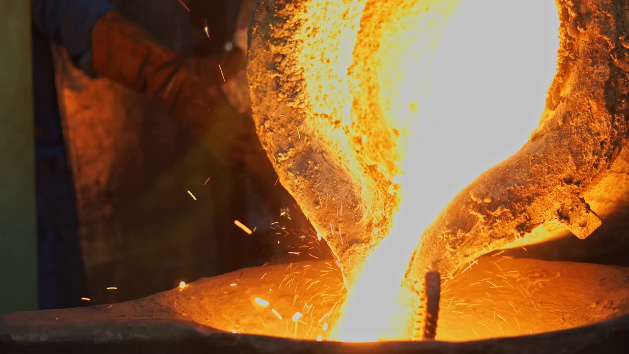熔化金属液，操作人员努力工作，将熔化的金属液从炉中出到钢包，然后浇注到铸造厂视频下载