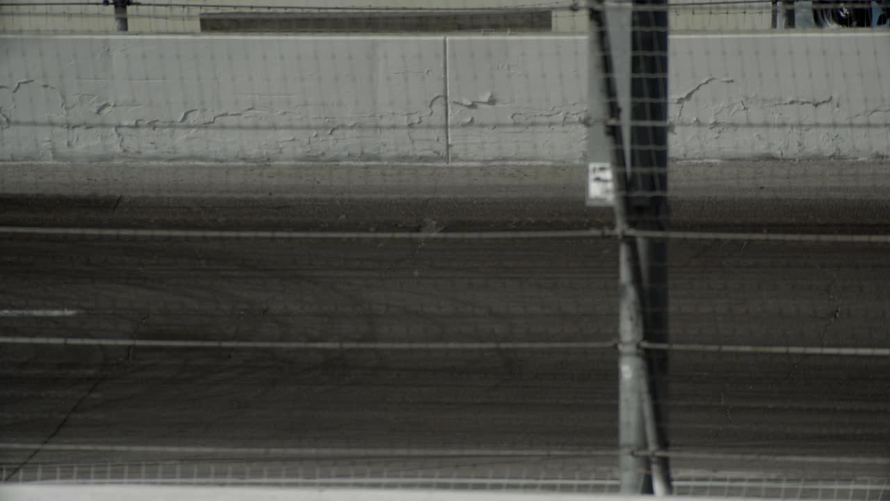 从右到左的中等角度的赛车行驶在irwindale高速赛道上。可能是种族。视频素材