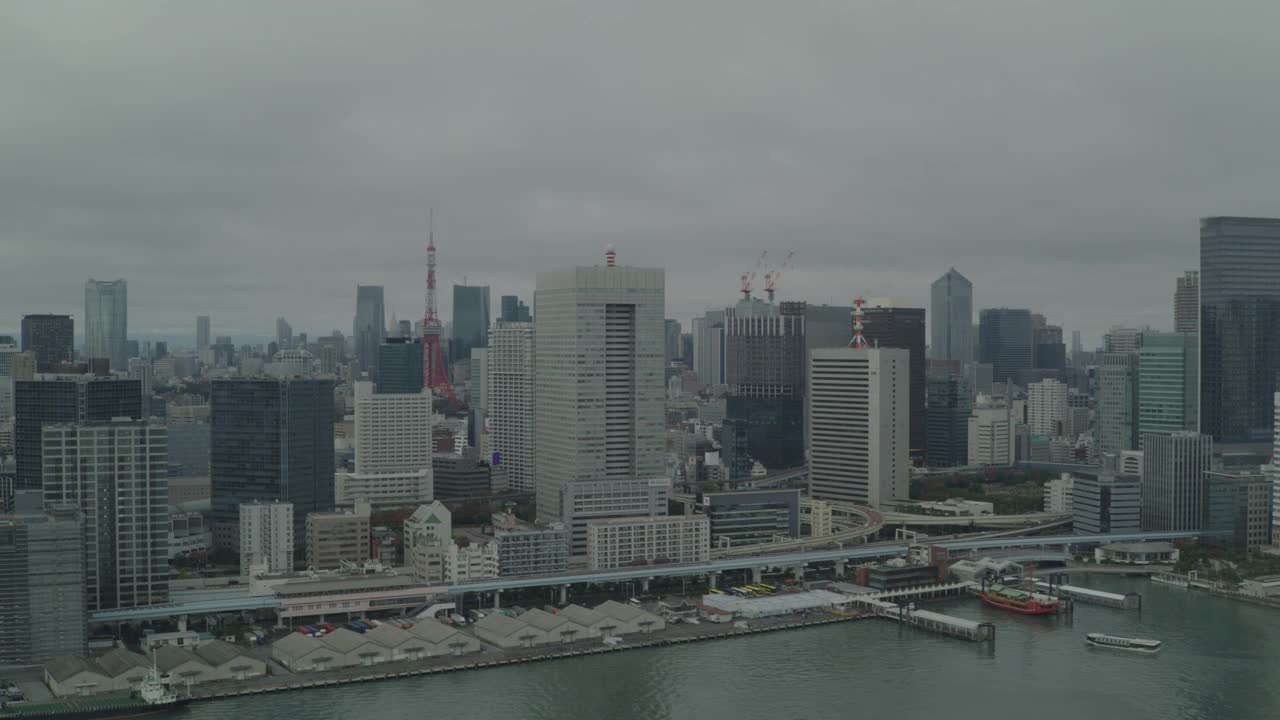空中东京城市天际线与东京塔可见。高楼大厦、摩天大楼和办公楼随处可见。东京湾可见。视频下载