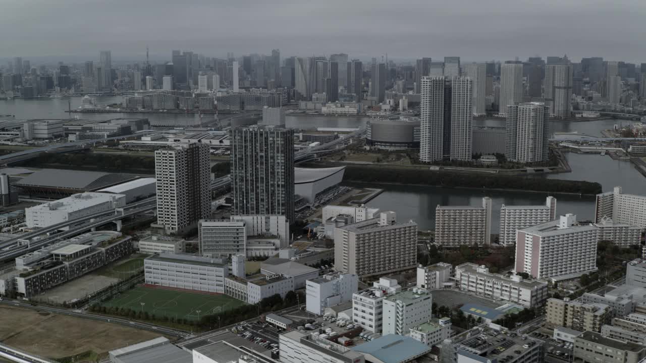 空中东京城市天际线。摩天大楼、高层建筑、办公楼和高速公路随处可见。河可见。在海滨可见的Ariake竞技场。视频素材