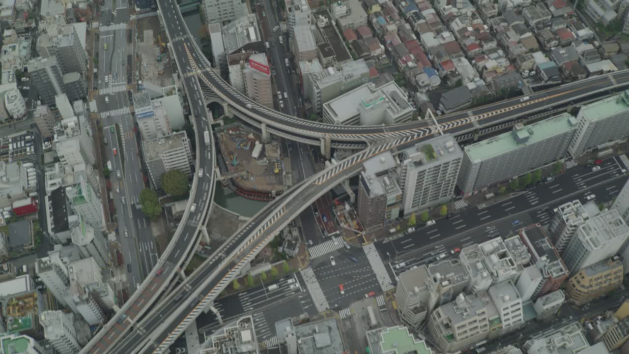 空中高角度下的汽车驾驶在高速公路或高速公路运行通过东京。高楼大厦、办公楼和公寓楼的屋顶随处可见。视频下载