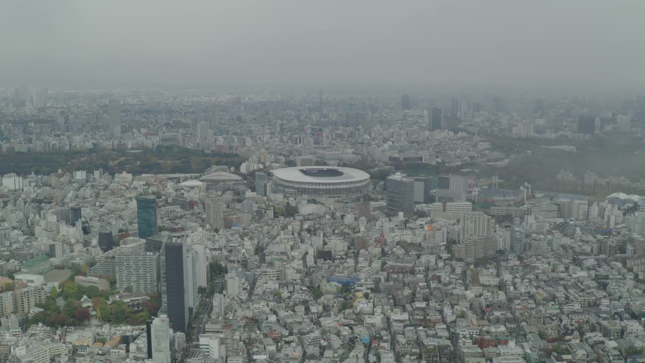 空中放大的日本国家体育场，原来的新国家体育场。城市周围体育场。高楼大厦、摩天大楼、办公楼、公寓楼和公园随处可见。视频素材