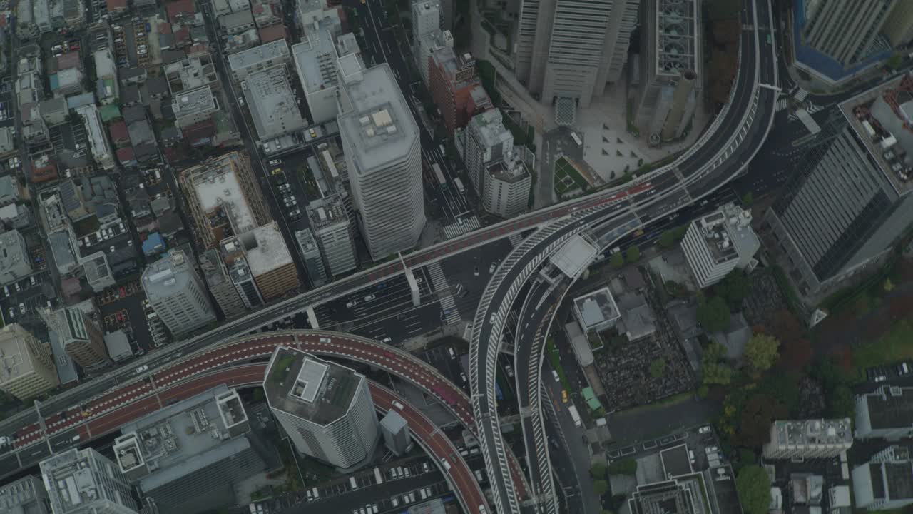 空中高角度下的城市街道，高速公路，或高速公路通过东京。可以看到高楼、摩天大楼、办公楼和公寓楼的屋顶和屋顶。视频素材