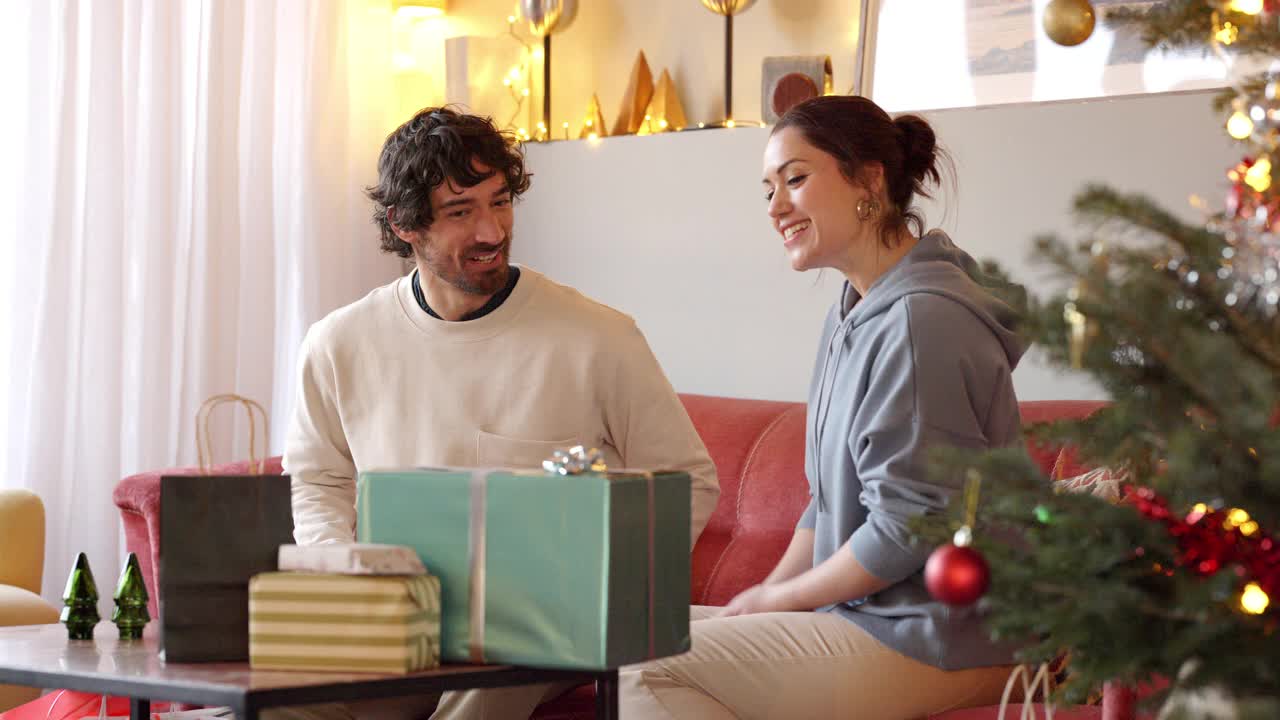 幸福的夫妇在家里交换圣诞礼物视频下载
