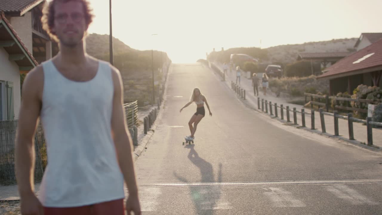 一个年轻女子在日落时滑滑板下山视频下载