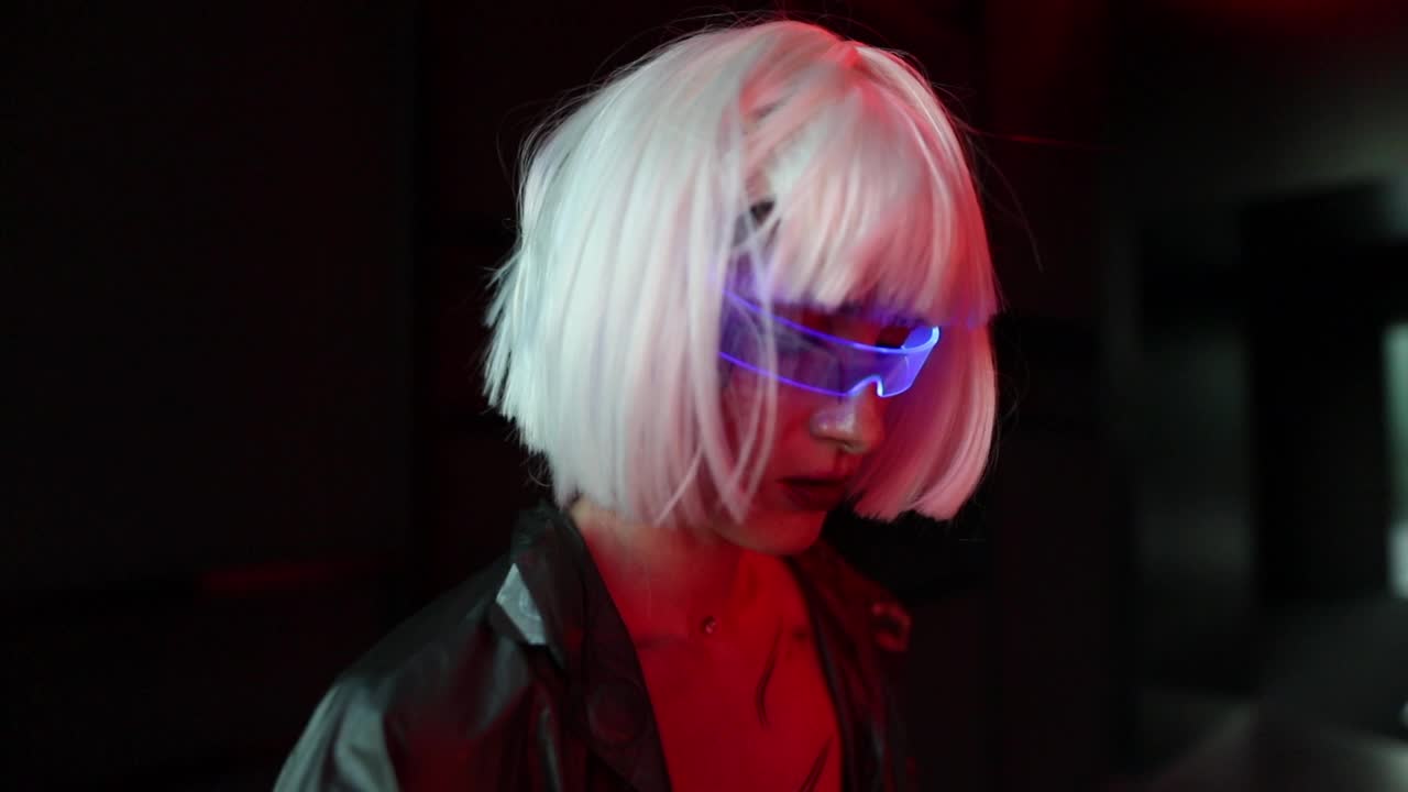 一个戴着网络眼镜的女人站在霓虹灯的黑暗中视频下载
