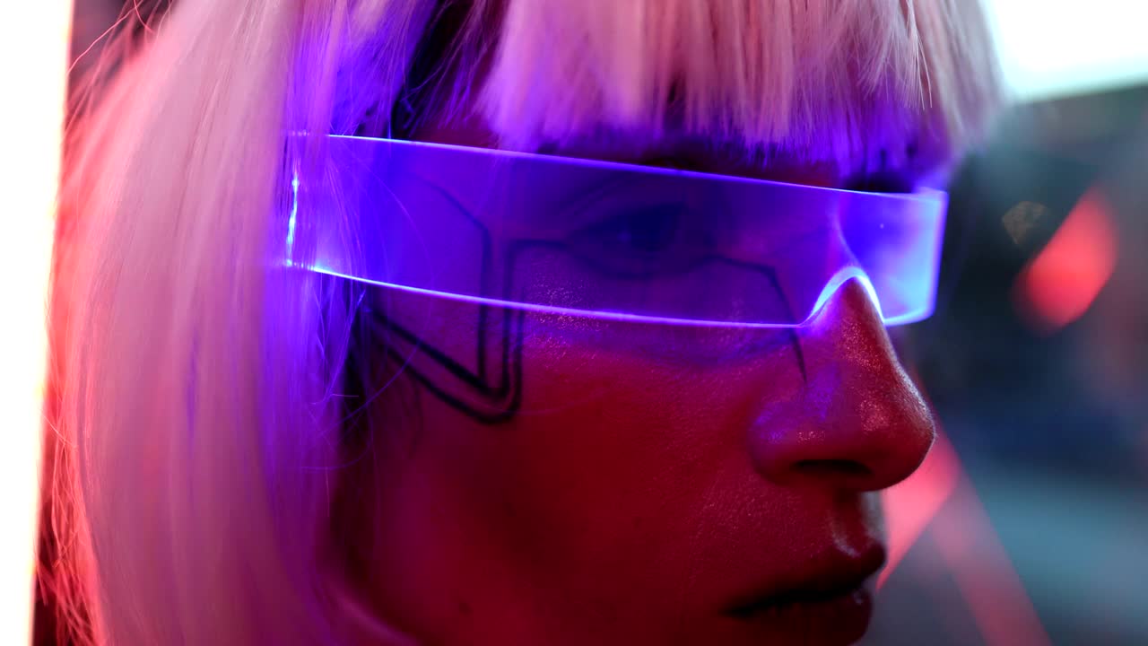 金发女郎戴着霓虹灯眼镜，坐在一个充满未来感的房间里，望着窗外视频下载