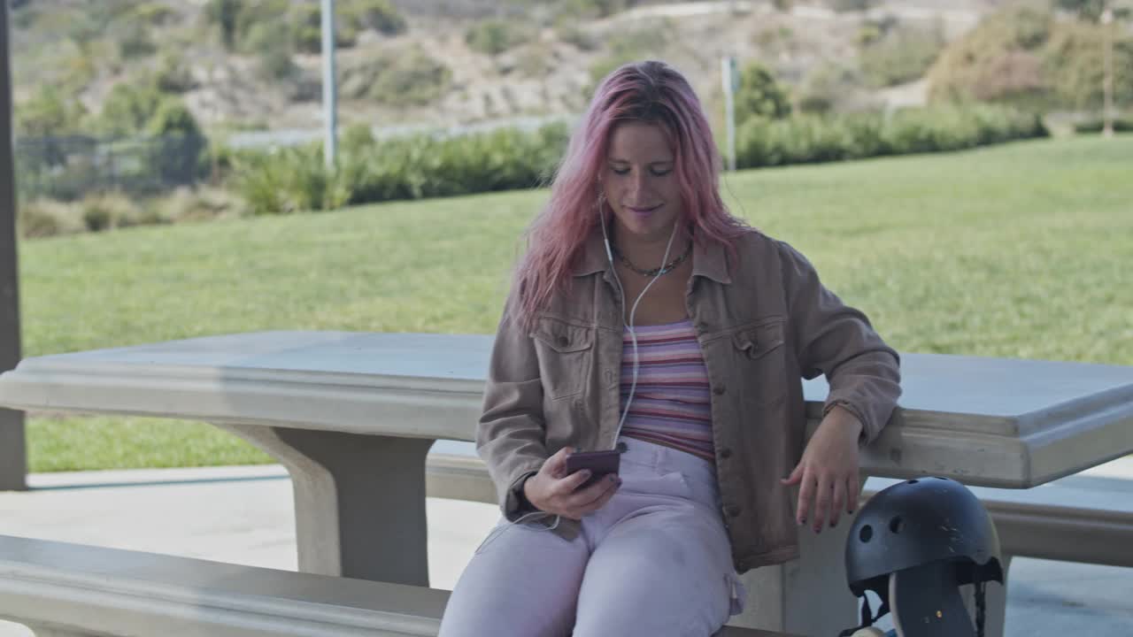 一个粉色头发的年轻女子在视频聊天视频素材
