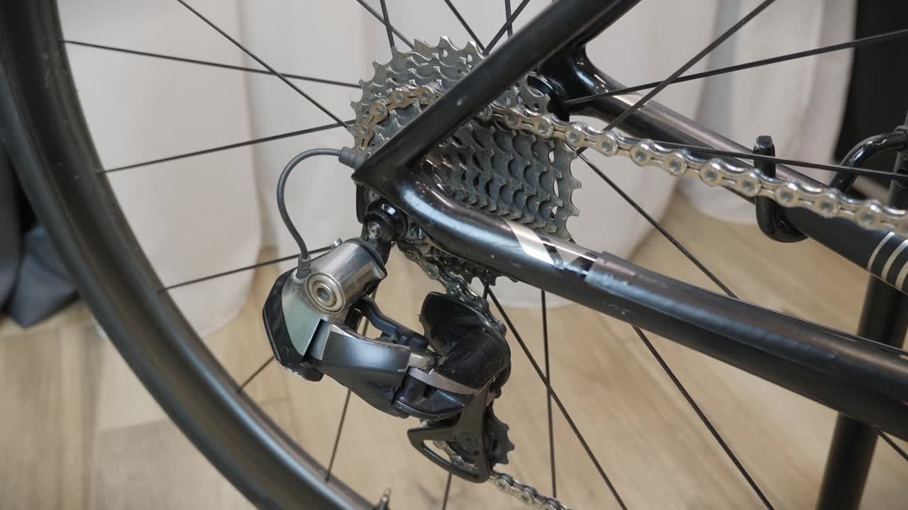 自行车车轮和自行车齿轮在运动。自行车车轮旋转。自行车齿轮和轮胎。带磁带和链条的自行车后轮，自行车传动系统。车间修理自行车视频素材