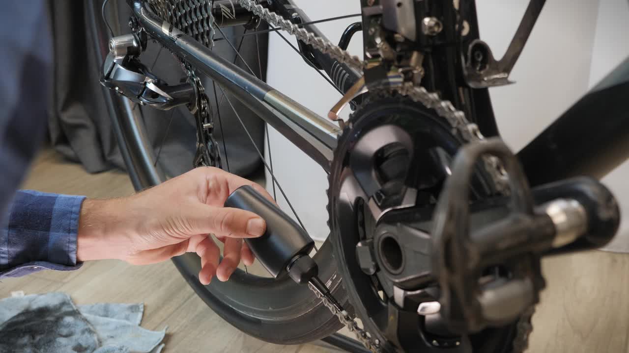 机械师给自行车链条上油。自行车准备。自行车维修和保养。自行车车间。润滑脂润滑链视频素材
