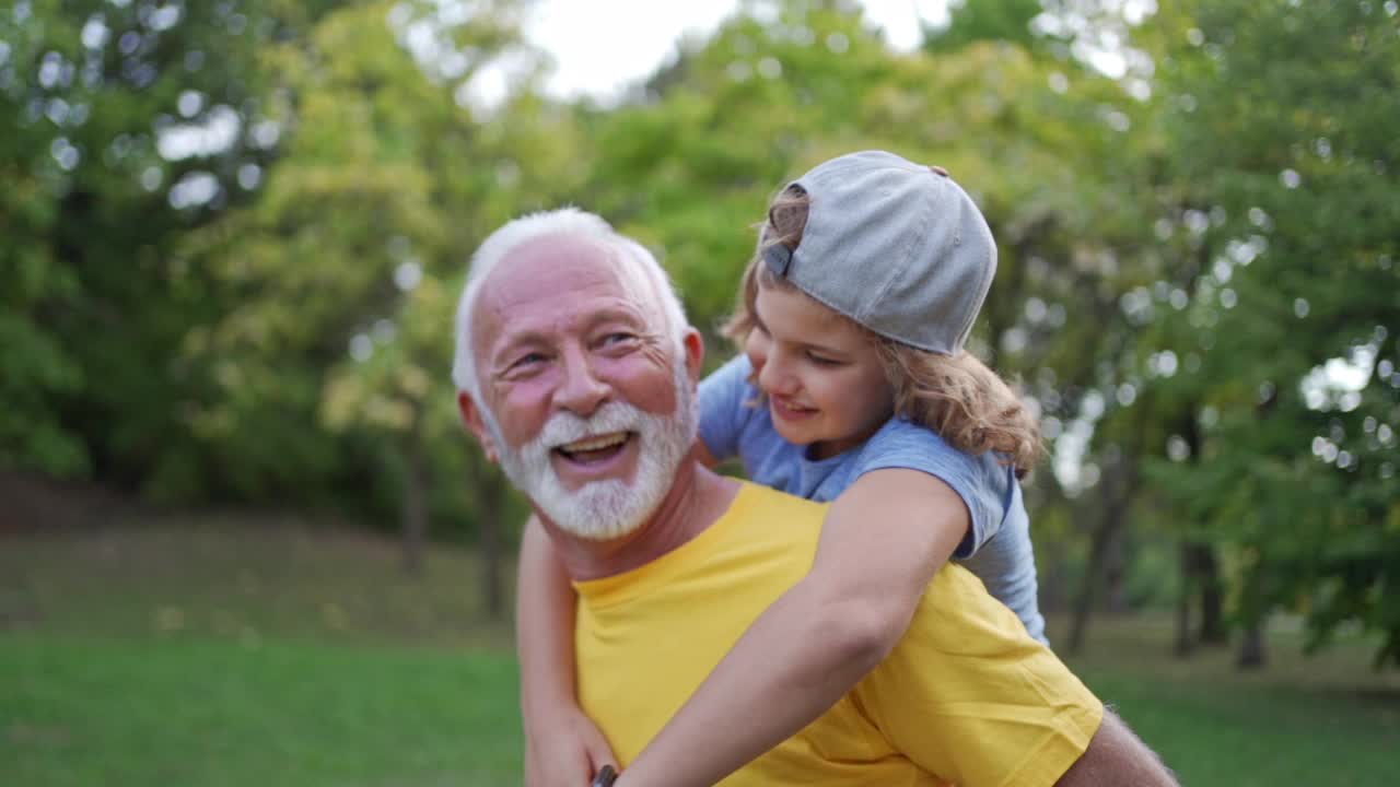 顽皮的孙子背着活泼健康的祖父，两人都在运动间隙玩耍视频下载