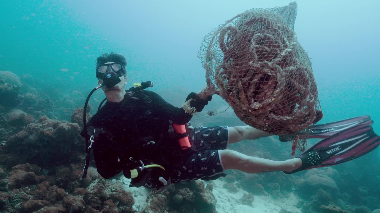 泰国潜水员正在清除水下鬼网污染视频素材