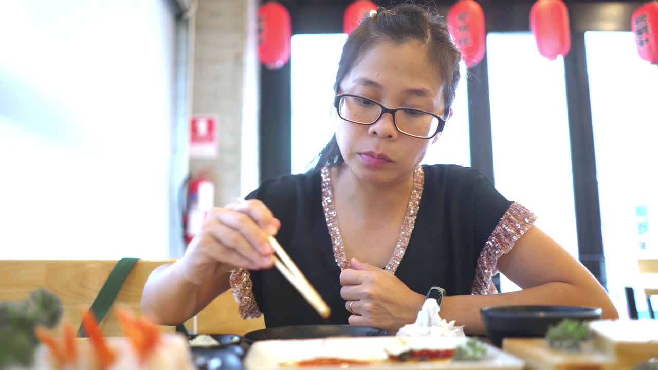 在日本餐厅吃鲑鱼生鱼片的女人视频素材