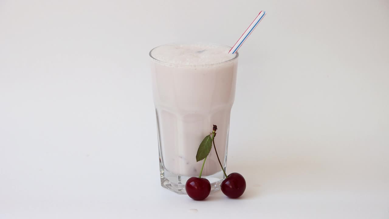 樱桃牛奶鸡尾酒，将奶昔倒入玻璃杯中。奶昔-健康食品。4 k的决议视频下载