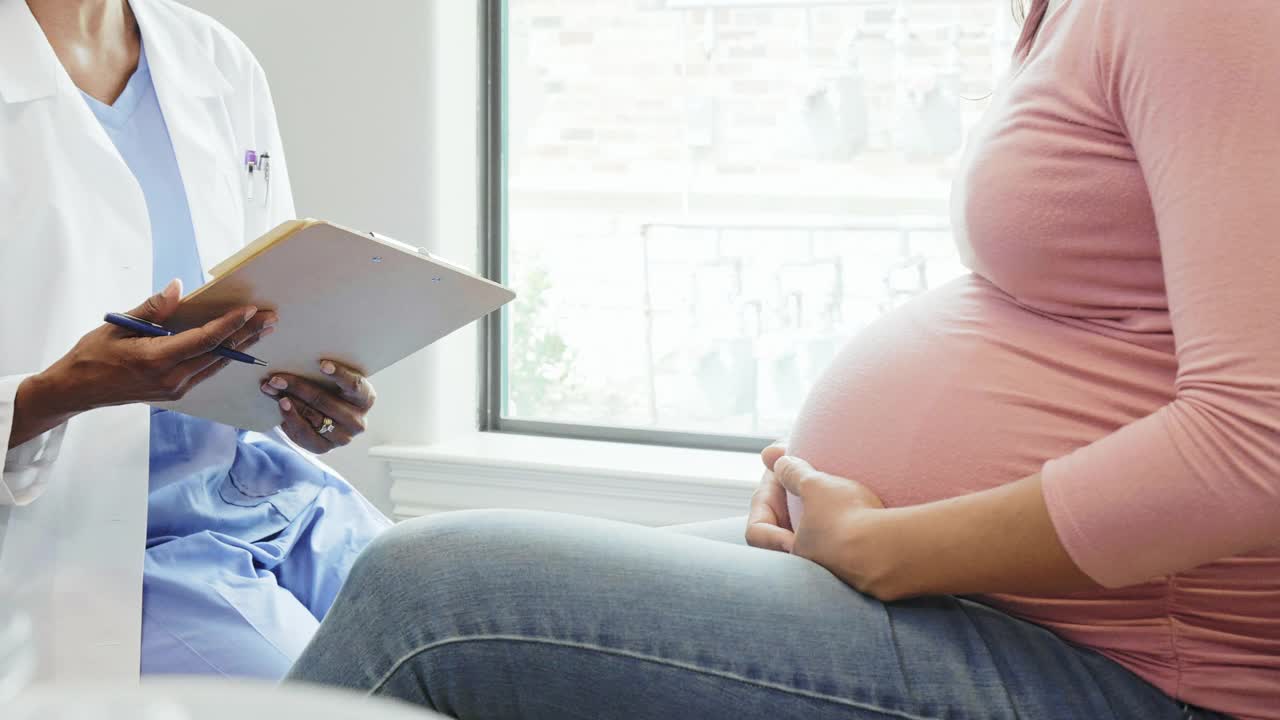 产前检查时，不知名的医生与孕妇交谈视频素材