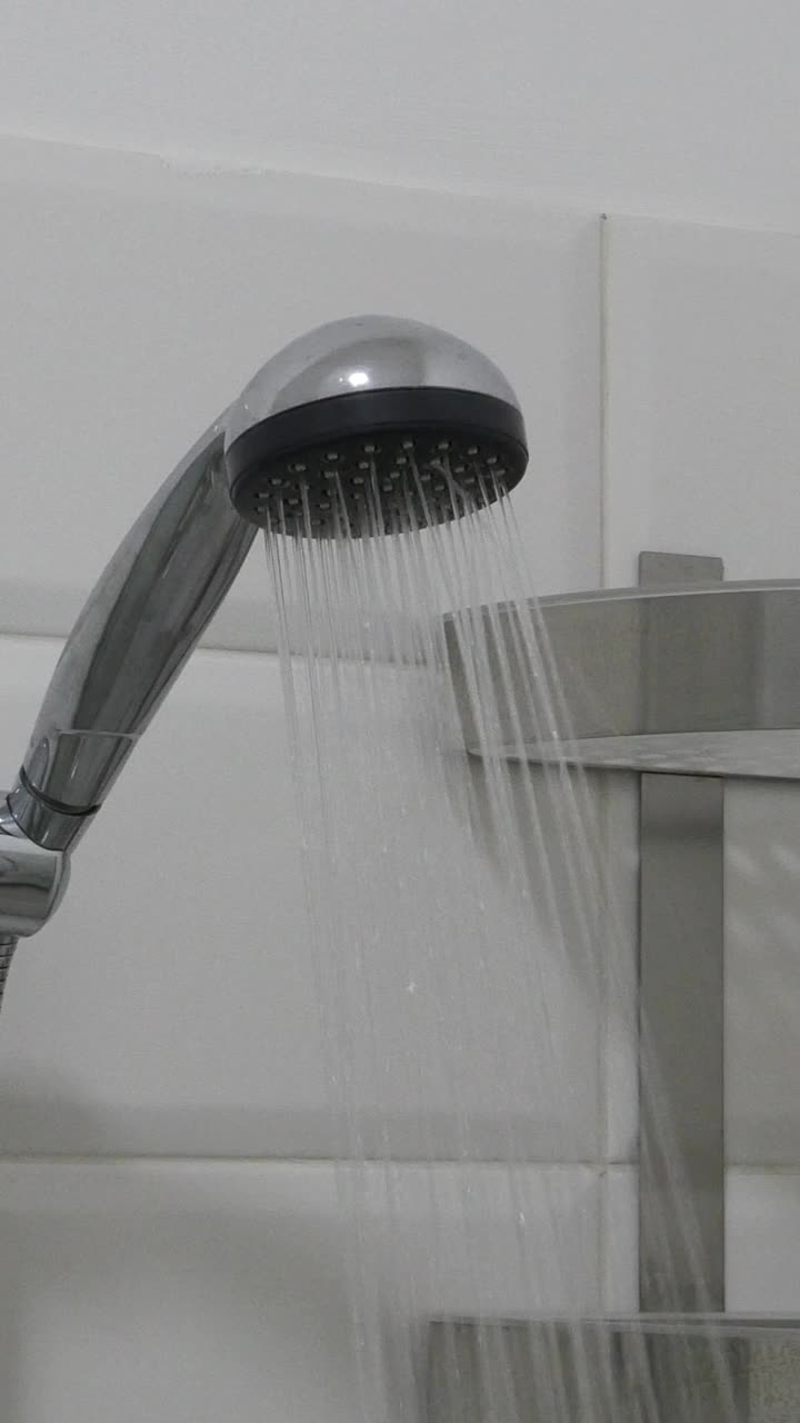 浴室内。淋浴头有水流。现代淋浴器在浴室里溅水。视频素材