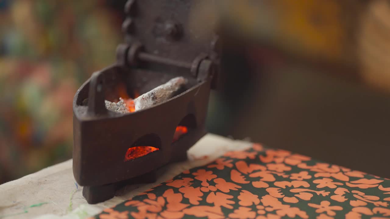近距离拍摄一位亚洲华裔女裁缝在她的工作室里给古董铁器具扇风，在熨布前加热视频下载