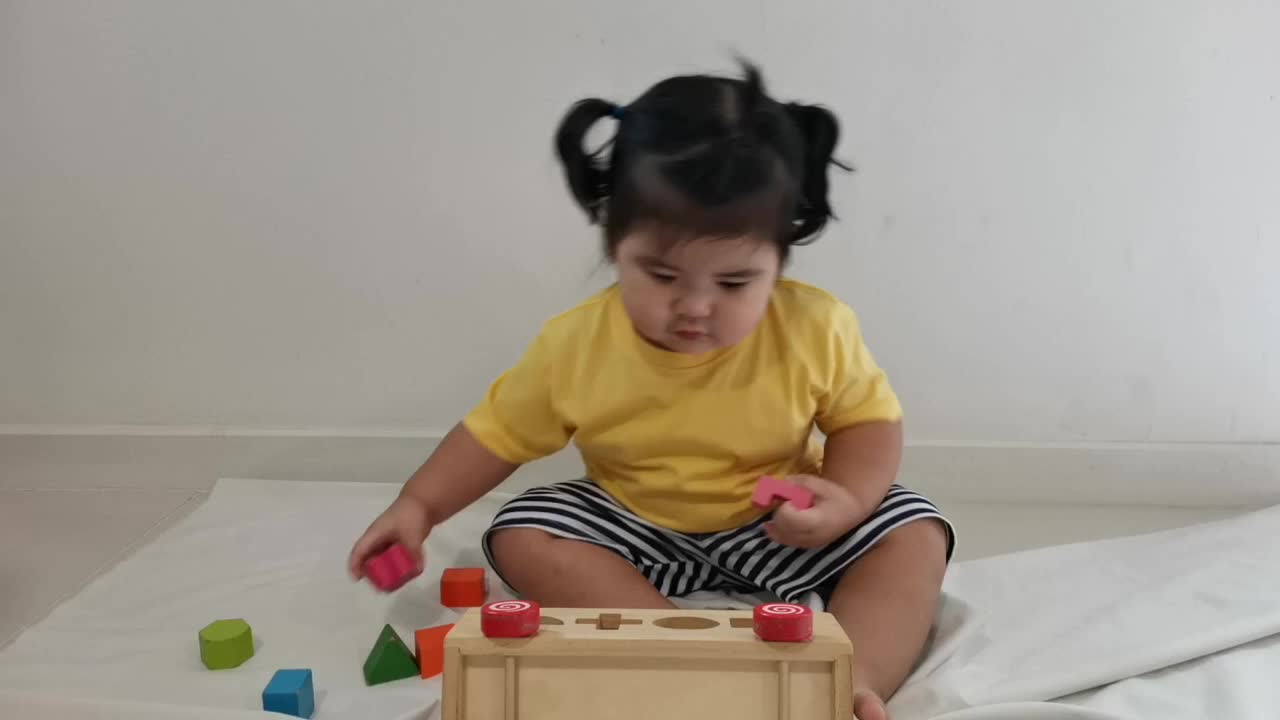 亚洲小女孩在地板上玩木块。视频素材