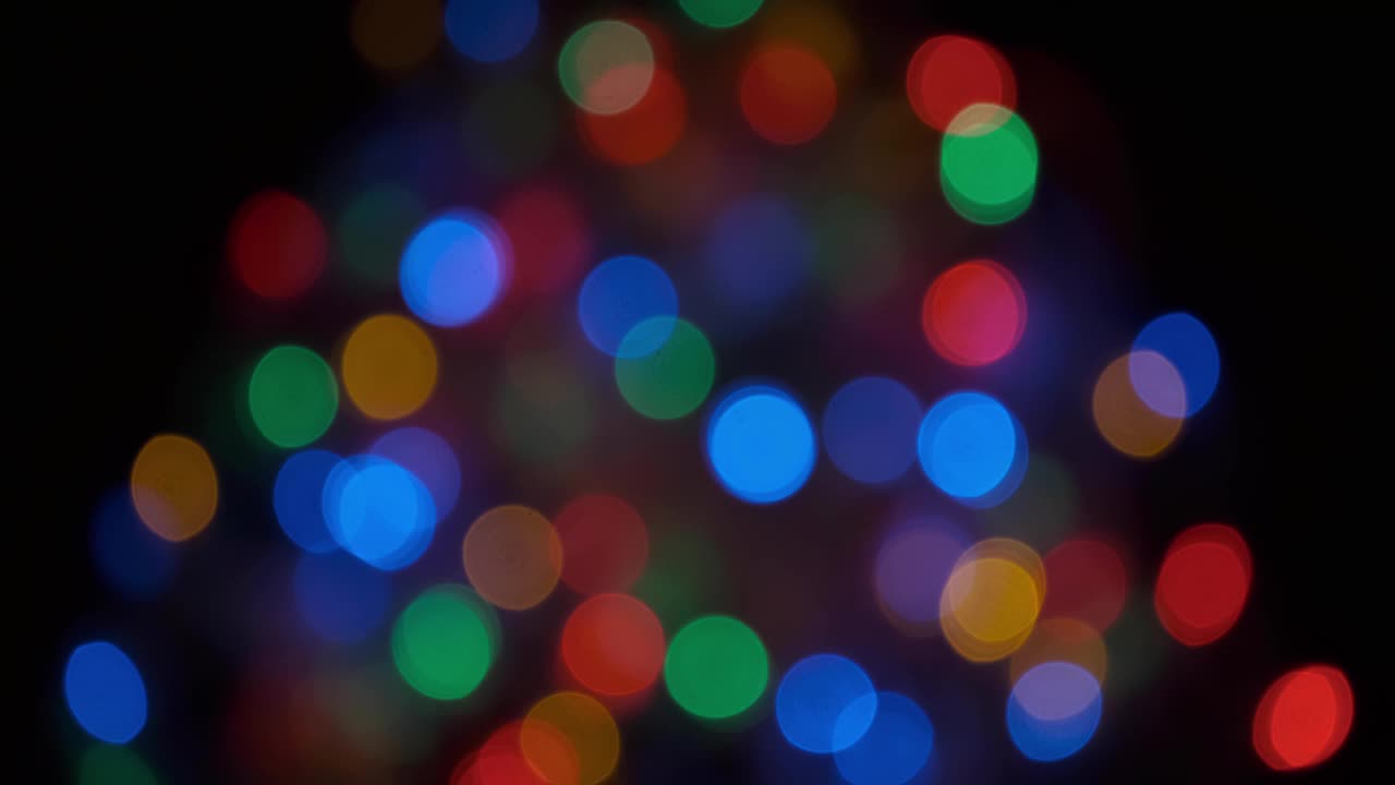 五颜六色的圣诞树散景背景下的闪烁灯光聚焦。视频下载