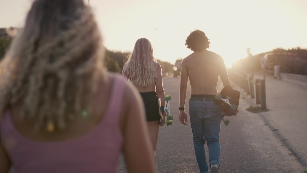 一群朋友踩着滑板在沙丘上行走视频素材