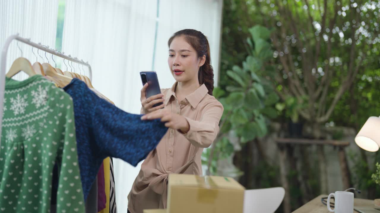 亚洲华裔女性在家庭办公室工作，处理时尚服装的在线零售业务视频素材