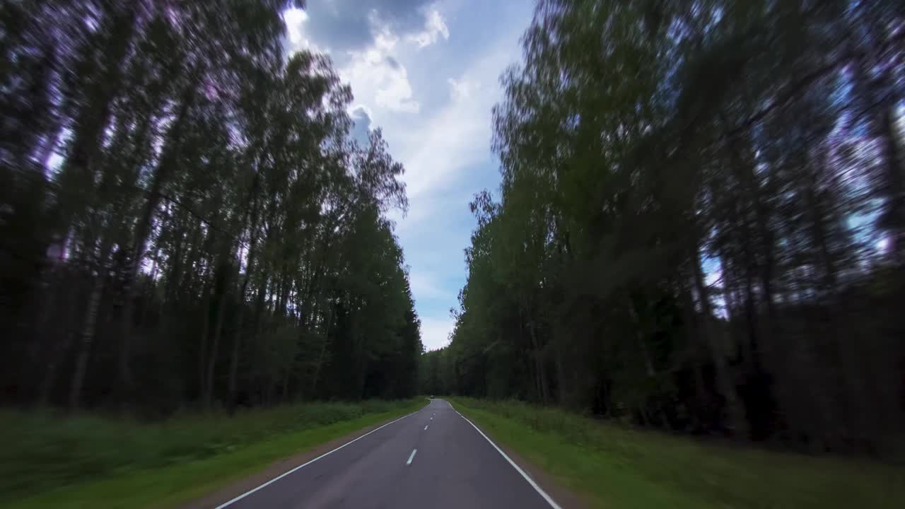 在穿过森林的乡间小路上开车视频素材
