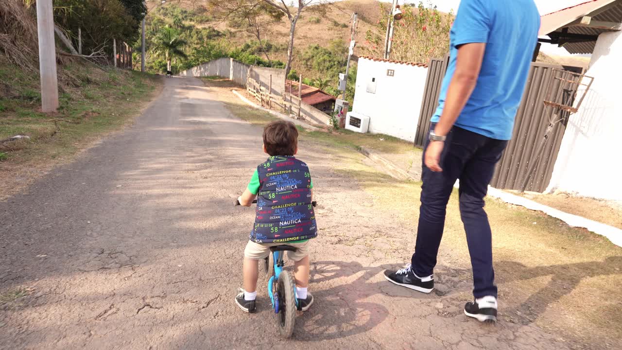 父亲在教他的小男孩骑自行车视频下载