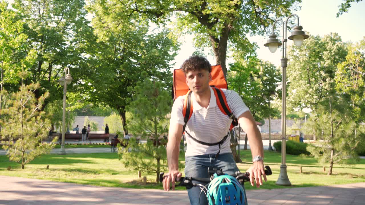 一个骑着自行车在城里送食物的送货员视频素材